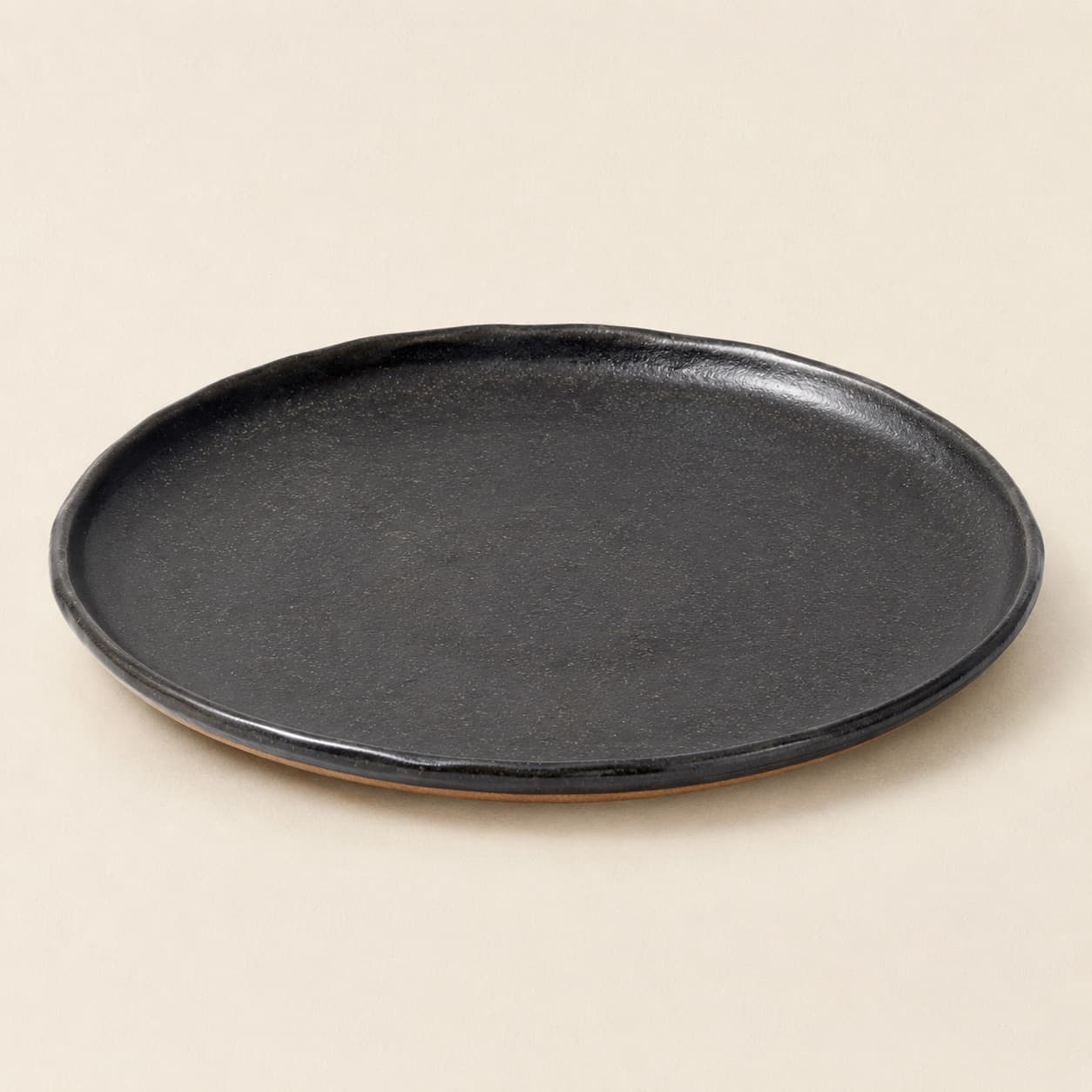 Cake Plate Ø30 — charcoal glazed stoneware with an unglazed clay foot ring.