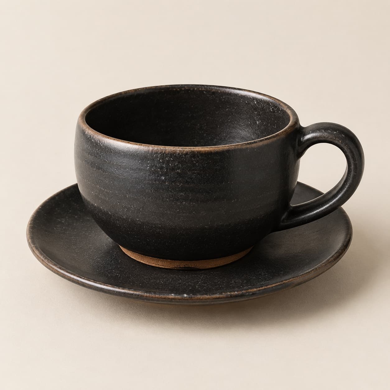 Cappuccino Cup 220 ml + Saucer — charcoal glazed stoneware with an unglazed clay foot ring.