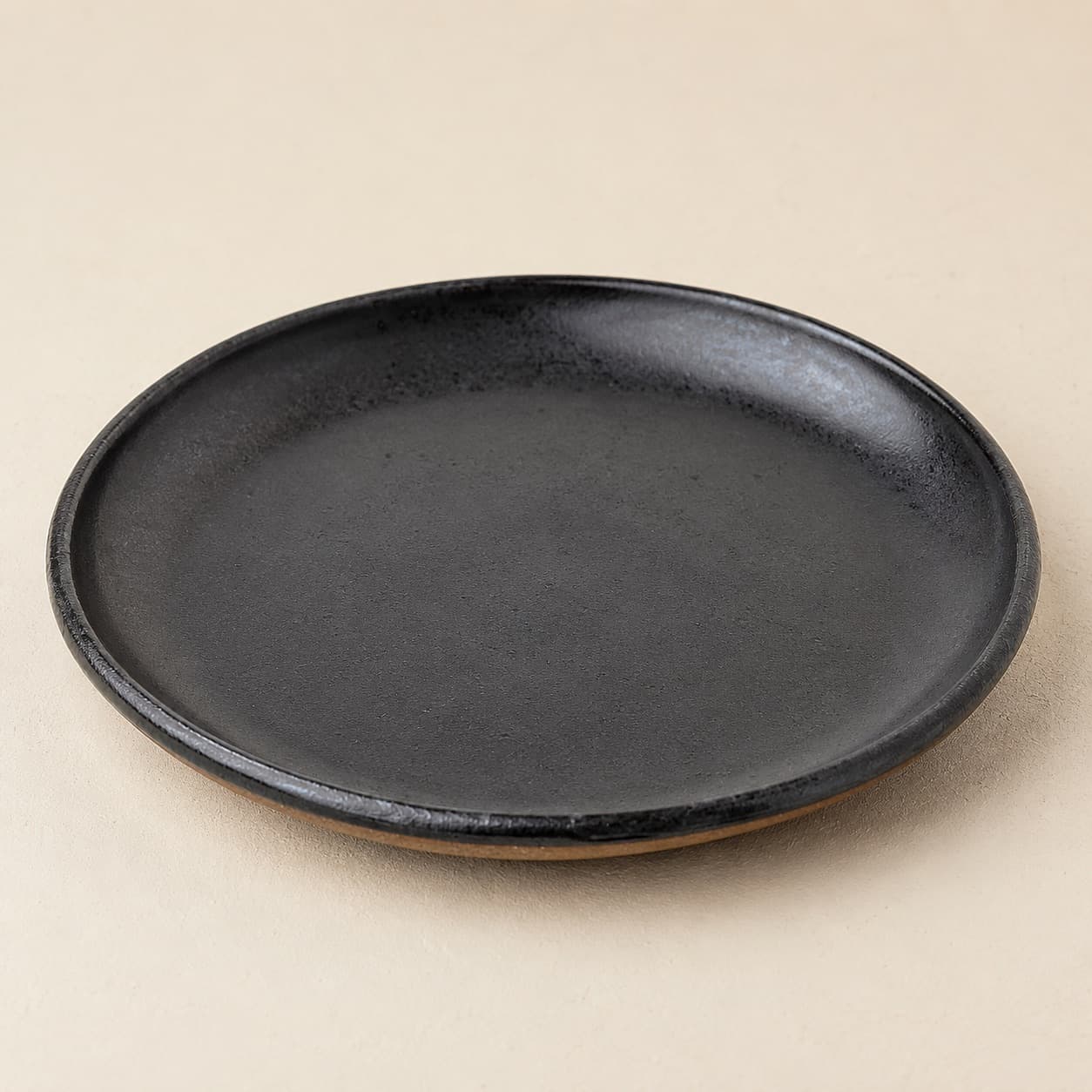 Dessert Plate Ø19 — charcoal glazed stoneware with an unglazed clay foot ring.