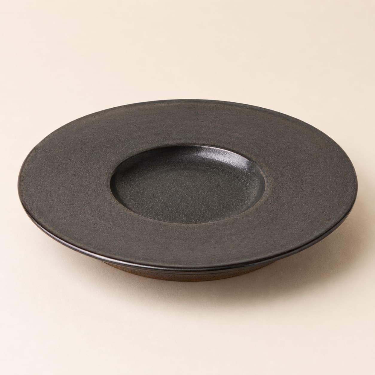 Dinner Plate Ø28 Wide-Rim — charcoal glazed stoneware with an unglazed clay foot ring.