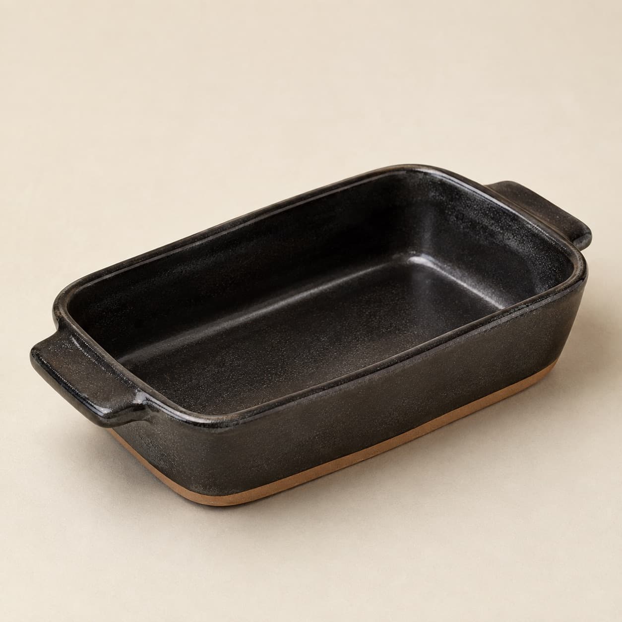 Gratin Dish 22×14 — charcoal glazed stoneware with an unglazed clay foot ring.