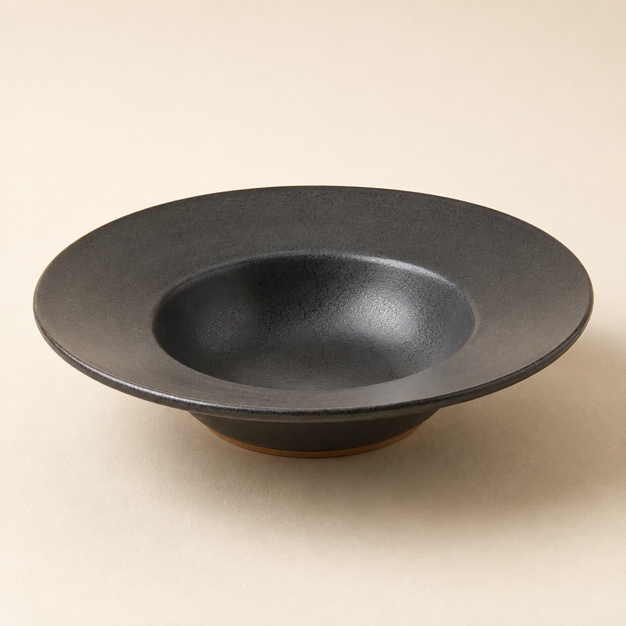 Pasta Plate Ø24 Deep — charcoal glazed stoneware with an unglazed clay foot ring.