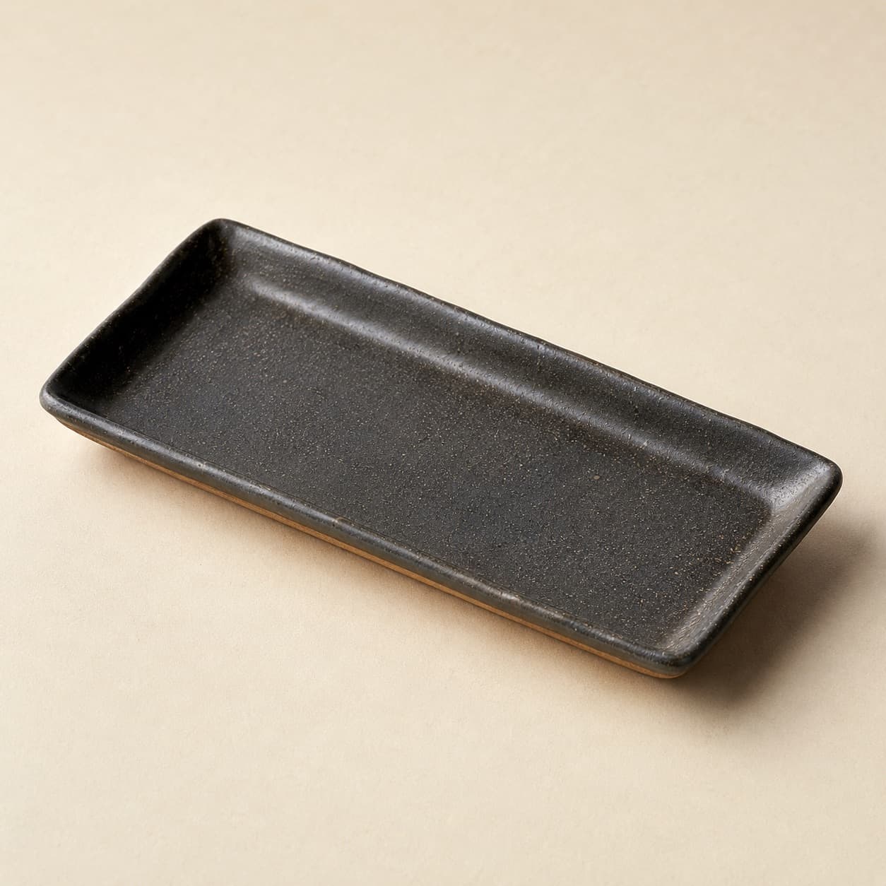 Rectangular Plate 28×14 — charcoal glazed stoneware with an unglazed clay foot ring.
