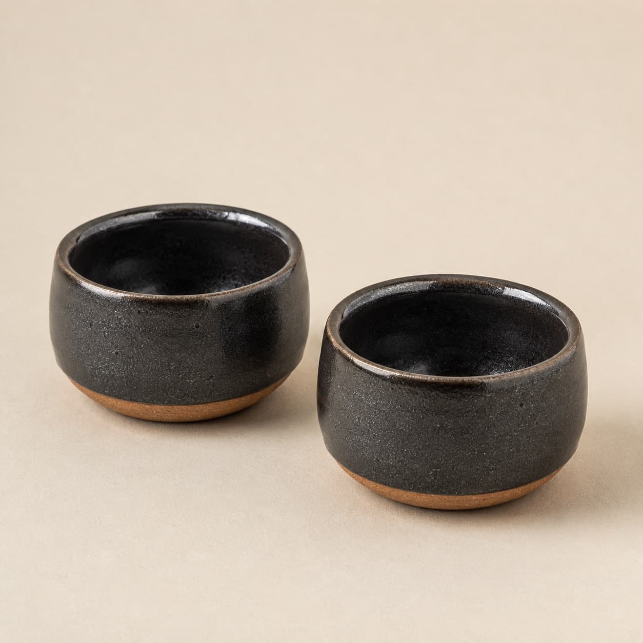 Salt & Pepper Cellar Pair — charcoal glazed stoneware with an unglazed clay foot ring.