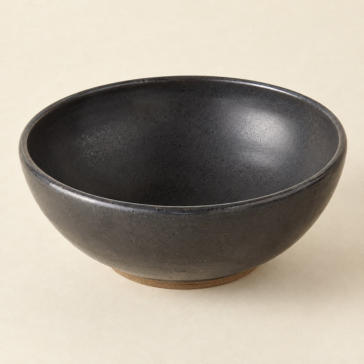 Serving Bowl Ø28 — charcoal glazed stoneware with an unglazed clay foot ring.