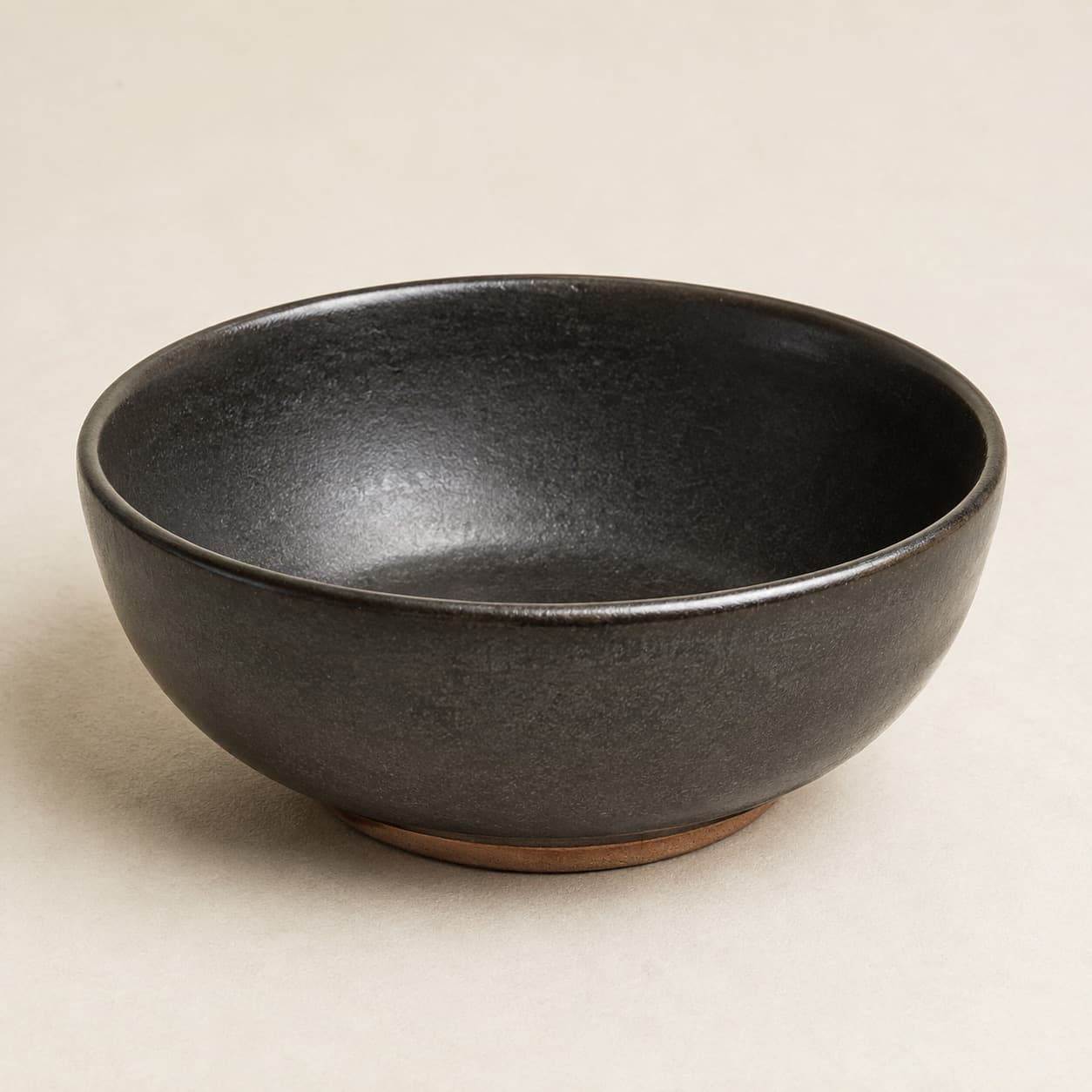 Soup Bowl Ø18 — charcoal glazed stoneware with an unglazed clay foot ring.