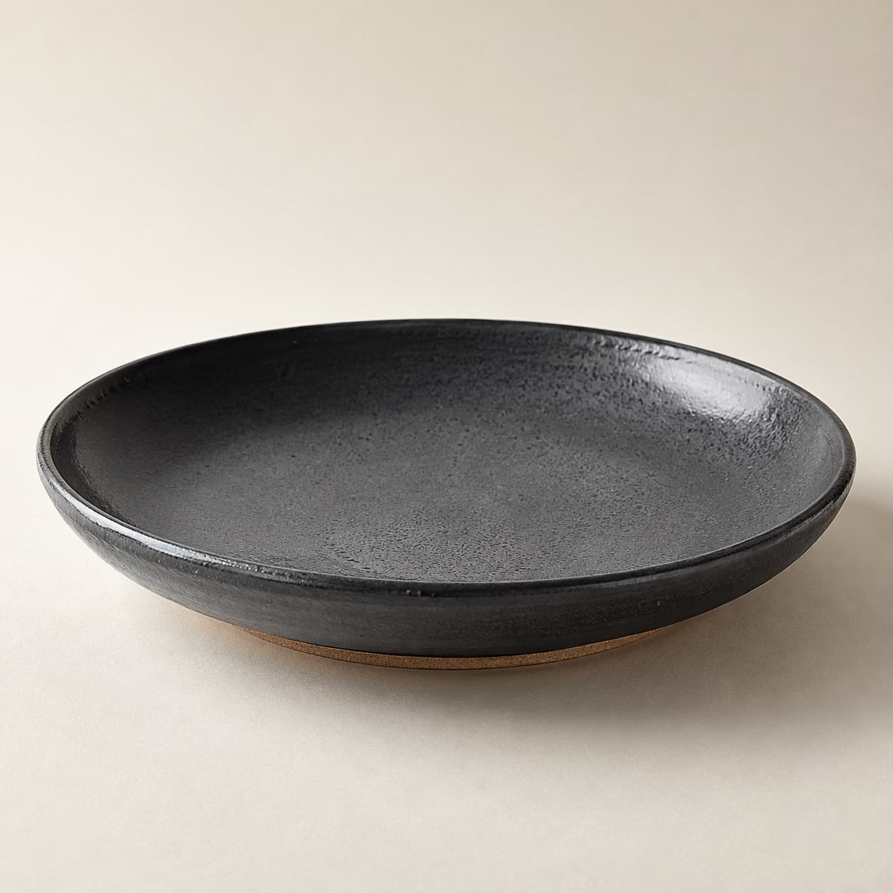Wide Shallow Bowl Ø26 — charcoal glazed stoneware with an unglazed clay foot ring.